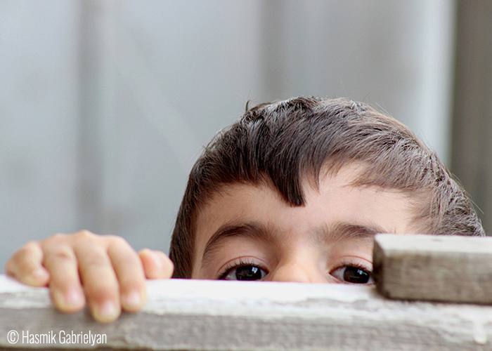 © Hasmik Gabrielyan (Etchmiadzin, Armenia). “Half-Hidden Hello” – Our Yard/Etchmiazin – The naughty little boy, playing in the yard.